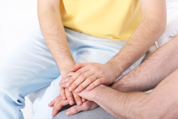 Happy gay couple holding hands together at home