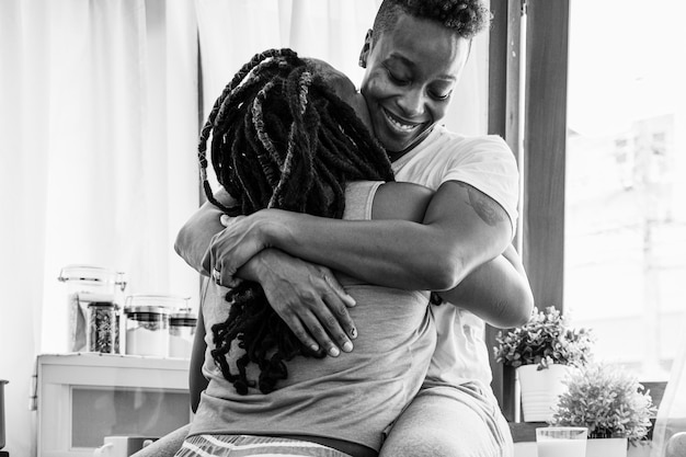 Photo happy gay couple hugging in the kitchen