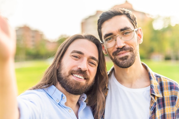 Felice coppia gay che si fa un selfie nel parco