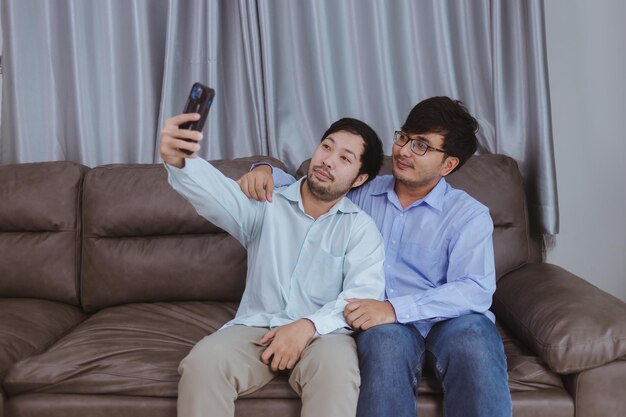 Happy gay couple taking a selfie with mobile phone.