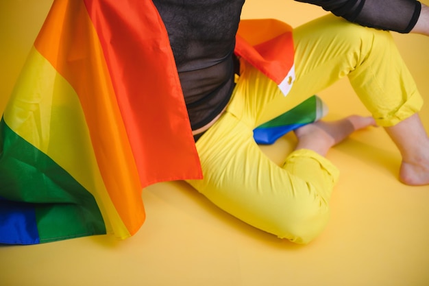 Happy gay man having fun holding rainbow flag symbol of lgbtq community