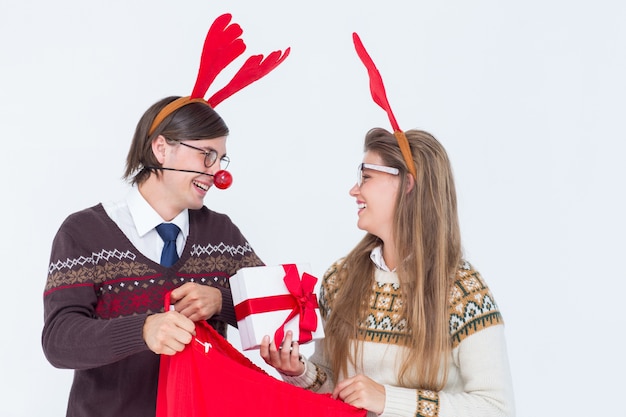 Foto presente felice della holding delle coppie dei pantaloni a vita bassa felici