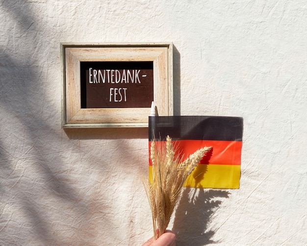 Happy Germany Thanksgiving Day of Erntedankfest in de Duitse taal Duitse vlag en bos tarweoren op beige textiel Plat bovenaanzicht