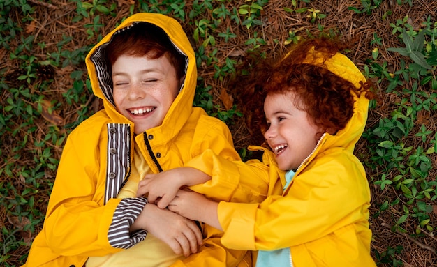 Happy ginger kids playing on forest ground