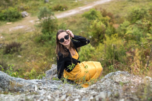 Happy girl on the background of the stone rocks. Summer time