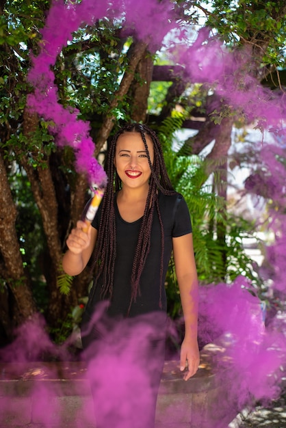 Happy girl, beautiful happy girl with colored smoke stick with natural light