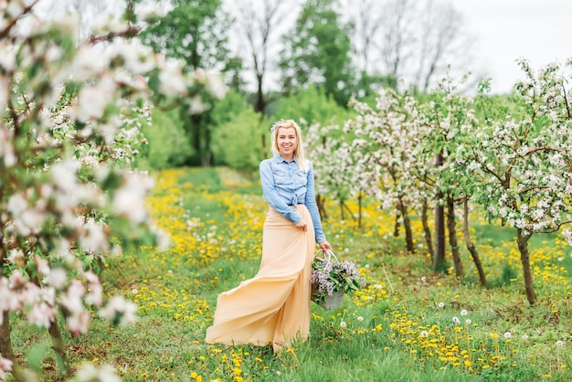 Happy girl in a blooming garden. blonde young woman in in spring blooming garden,