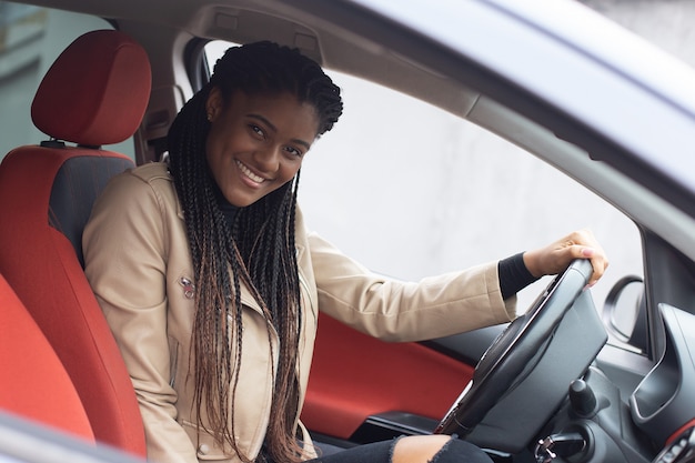 La ragazza felice in una macchina alla guida, afroamericano