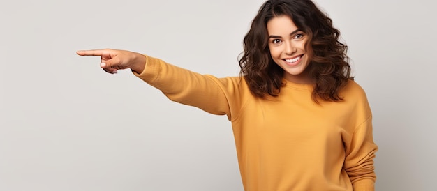 Happy girl in casual clothes pointing on white background