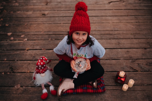 Ragazza felice che celebra il natale con luci ed elementi natalizi