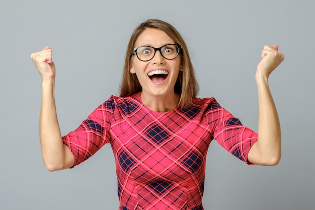 Ragazza felice che celebra il suo successo con le braccia alzate