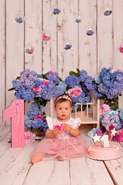 Happy girl child in dress eating birthday cake