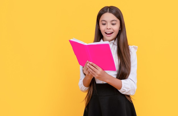 Happy girl child read school textbook yellow background reading