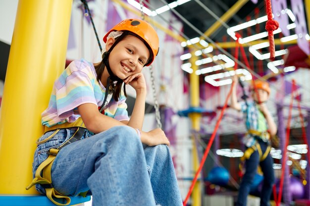 Happy girl in climbing area, kids spend the weekend on playground, active childhood