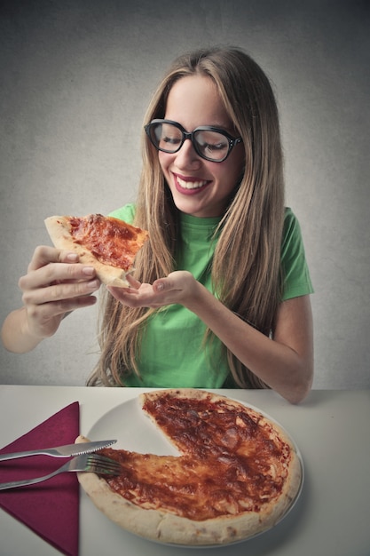 Foto ragazza felice che mangia pizza