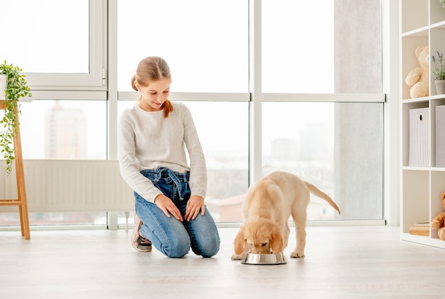 子犬を食べるの横にある幸せな女の子