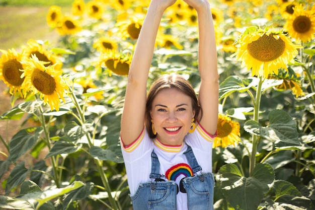 Happy girl enjoys spending time in a field with sunflowers