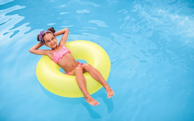 Happy girl floating on pool water