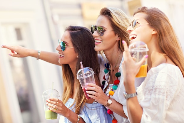 happy girl friends hanging out in the city in summer