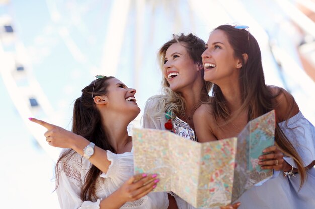 happy girl friends hanging out in the city in summer