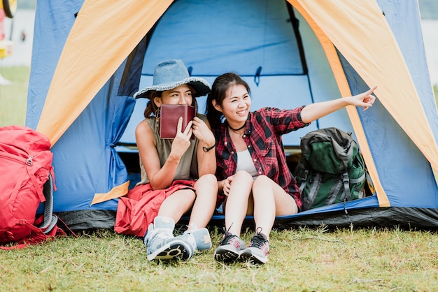 写真 キャンプ中にテントの前でハッピーな女の子の友人
