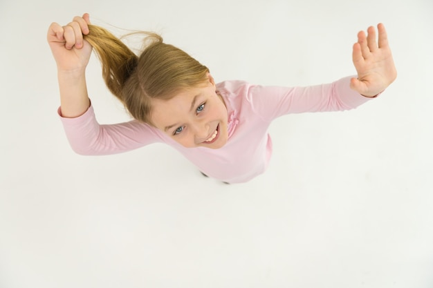 The happy girl gesture and hold her hair. View from above