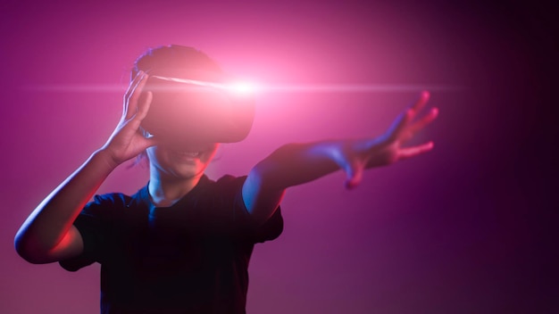 Foto ragazza felice in bicchieri di realtà virtuale. realtà aumentata, scienza, concetto di tecnologia futura. realtà virtuale. occhiali 3d futuristici con proiezione virtuale. luce al neon.