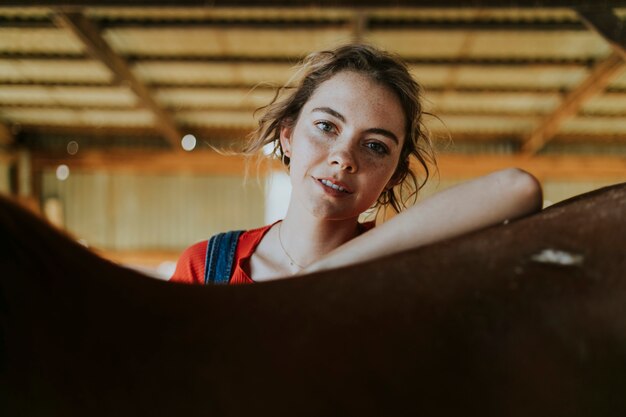 Happy girl grooming a chestnut horse