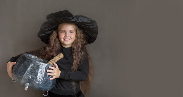 Счастливая девушка в костюме ведьмы на хэллоуин варит зелье