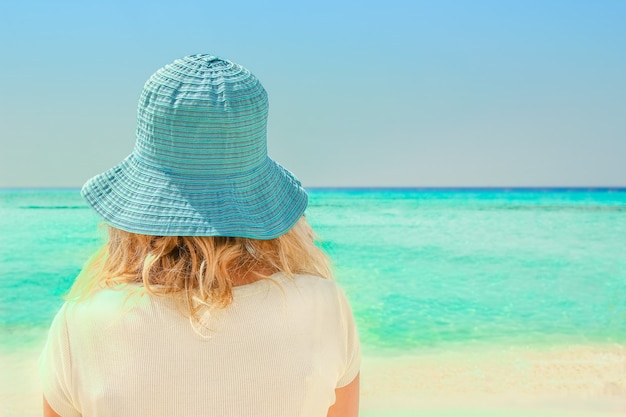 Happy girl in hat at the sea shore on the nature of Cyprus