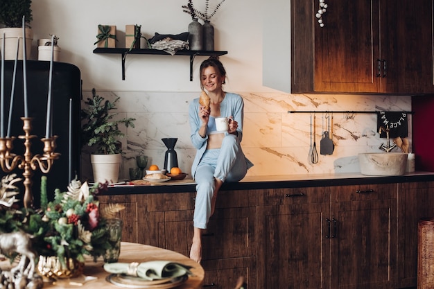 Foto ragazza felice che fa colazione a natale. mattina di natale