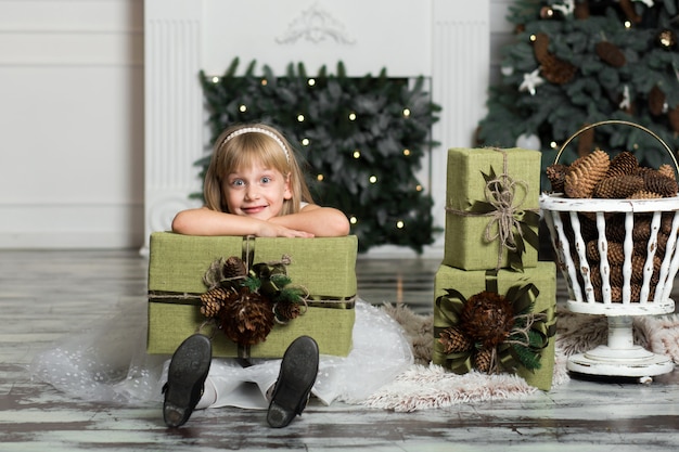 彼女の頭の上に贈り物の大きな箱を持って幸せな女の子。冬休み、クリスマス、人。