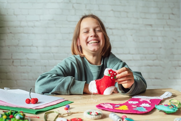 Happy girl holding handmade felt christmas sock, christmas crafting