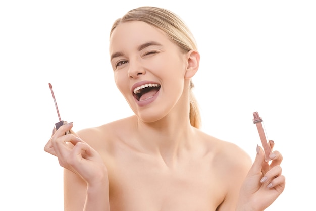 The happy girl holding a lip gloss on the white background