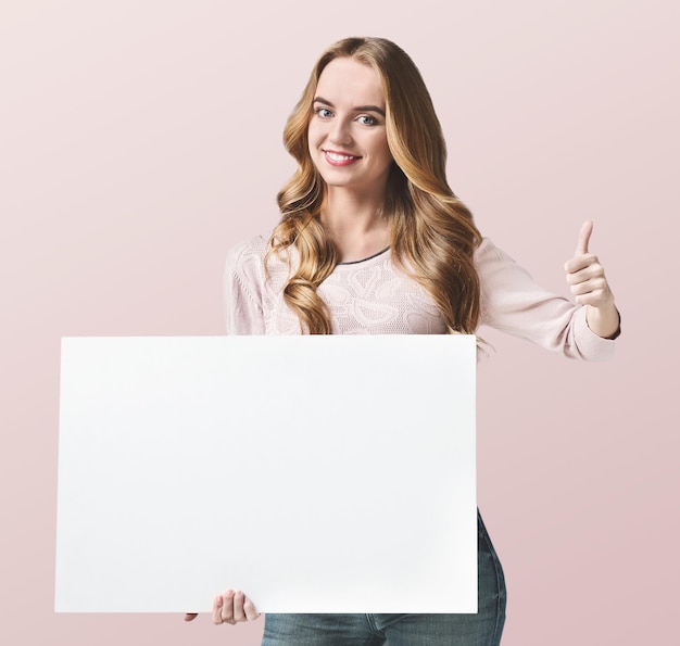 Happy girl holding a sheet of paper in her hand with thumbs- up gesture. Place for your text, concept, copy space, isolated