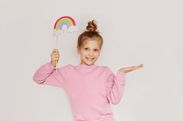 A happy girl holds a rainbow in the clouds made of felt