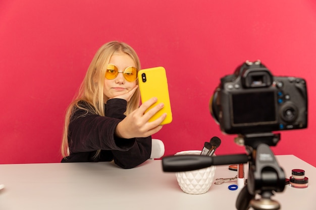 Happy girl at home speaking in front of camera for vlog