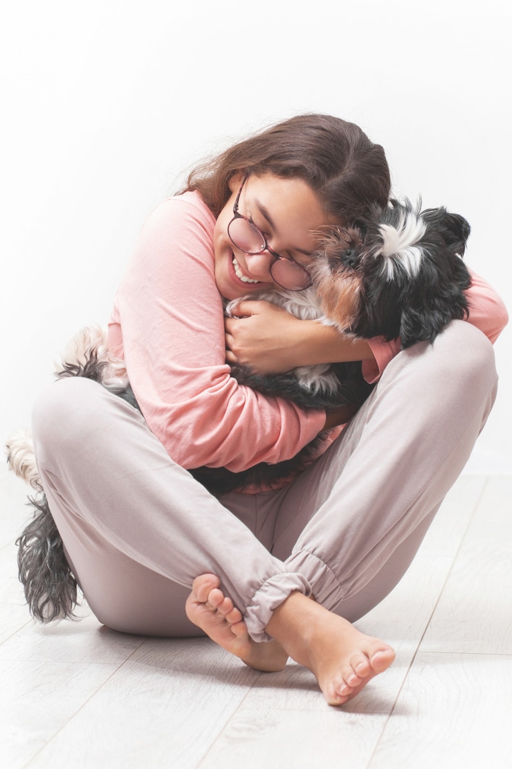 幸せな女の子は彼女の犬を抱擁します。