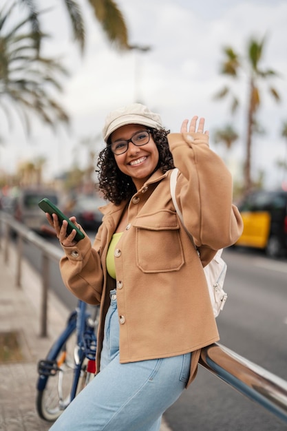 A happy girl is greeting friend on the street