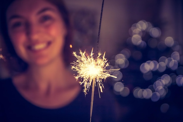 写真 クリスマスの時期に線香花火を持っている幸せな女の子