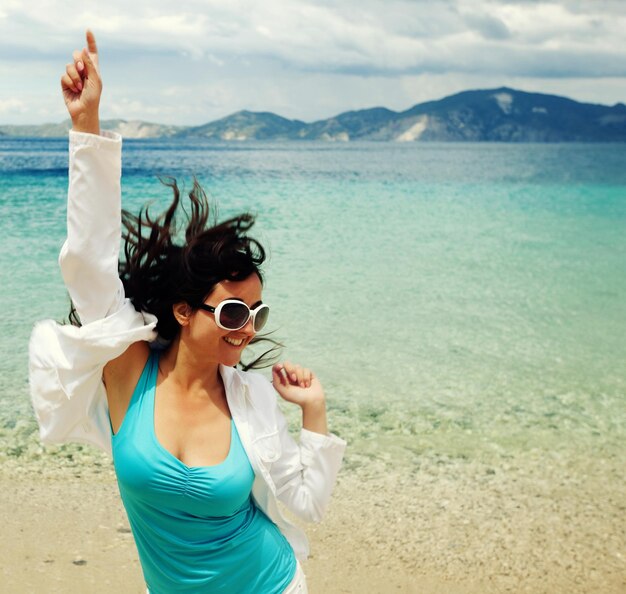 Photo happy girl jumping on the beach