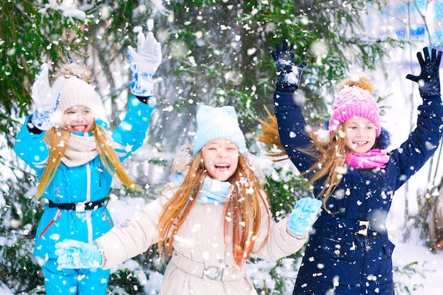 雪に覆われた森で踊る幸せな女の子の子供たち