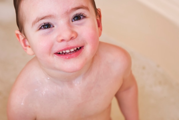 Happy girl laughing and bathed in the bath