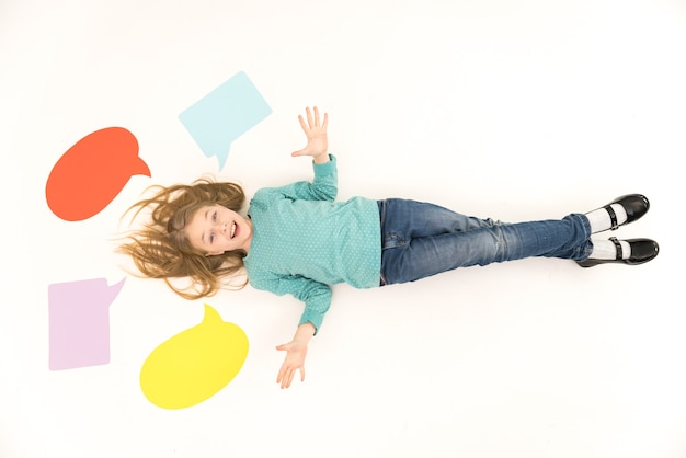 Photo the happy girl lay on the floor near the dialog signs. view from above