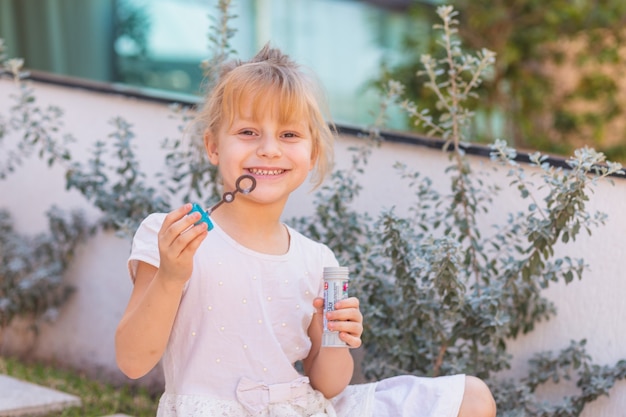 Happy girl making soap bubbles