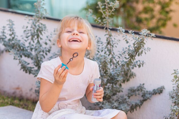 Happy girl making soap bubbles