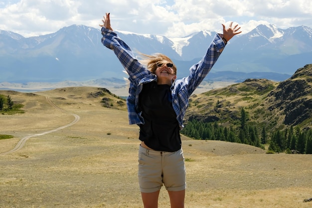 Happy girl in the mountains Joyful emotions A joyful girl in the way A girl jumping with happiness