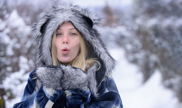 写真 暖かいコートの毛皮の帽子とミトンの冬の休日で雪の冬の日の美しい女性を再生する幸せな女の子