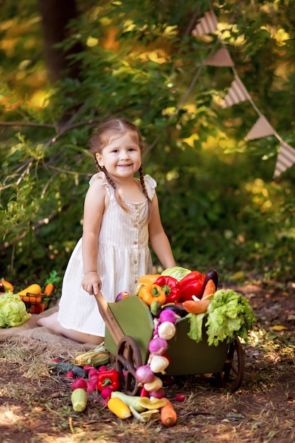 Happy girl prepares vegetable salad in nature