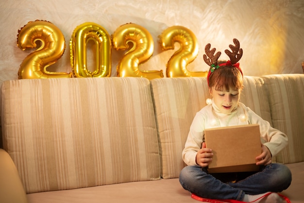 写真 幸せな女の子は木と新年の眼鏡をかけ、クリスマスに喜びます。メリークリスマスのコンセプト。